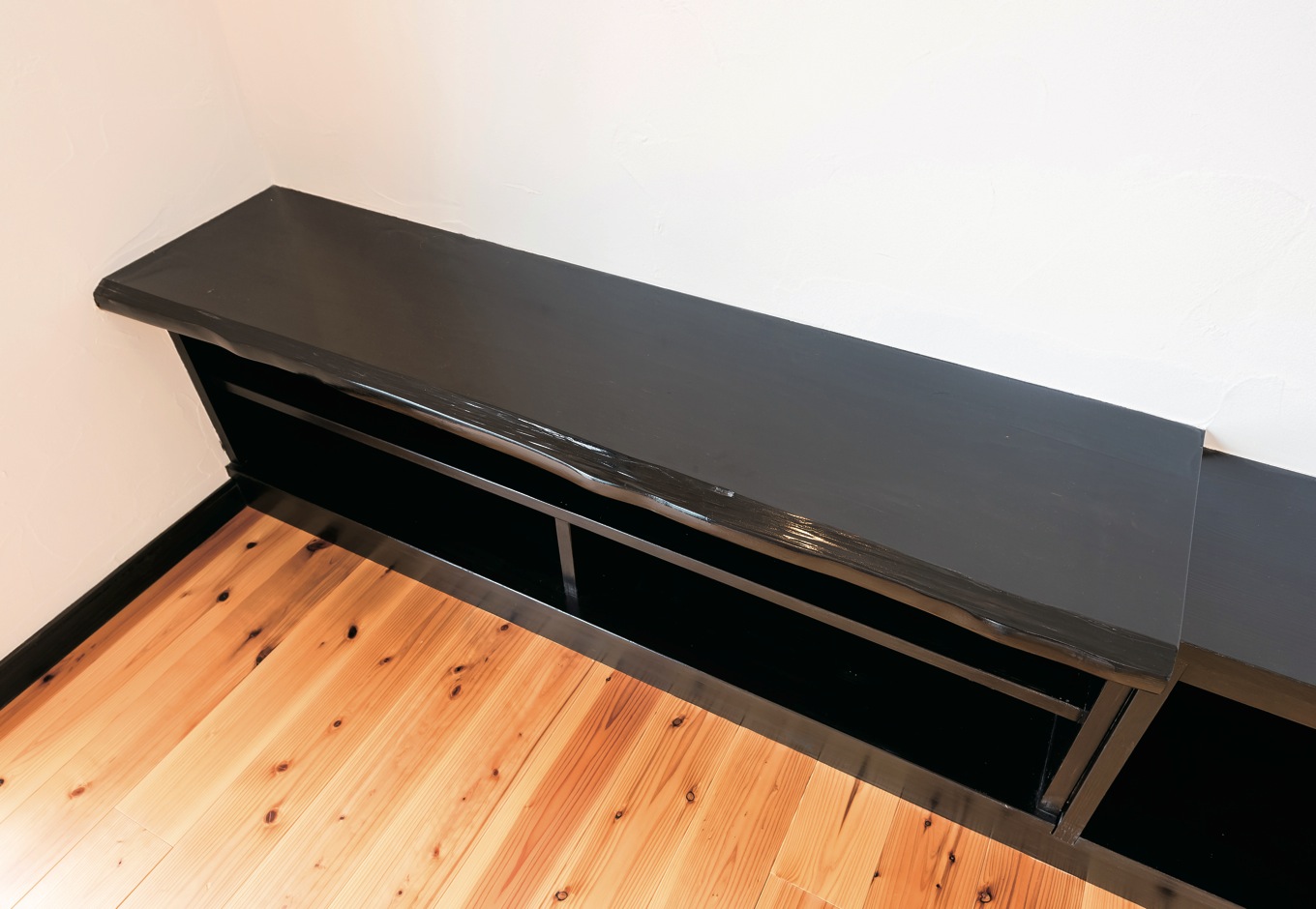 ハウテックス【1000万円台、自然素材、平屋】テレビボードは造作で。黒く塗装した一枚板が存在感を示す。白い塗り壁とのモノトーンもシックな印象