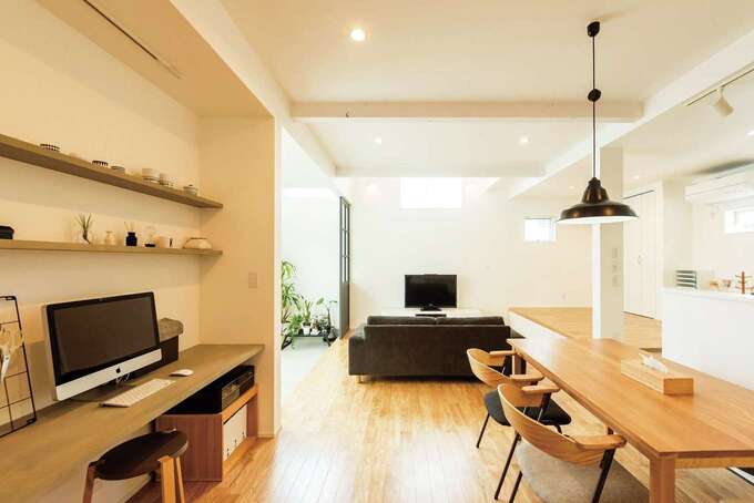 ダイニングの壁一面には造作のカウンターとオープンシェルフが。現在はパソコンスペースに。対面キッチンからちょうど正面の位置で、将来は奥さまの目が届きやすい、子どもの宿題スペースになる予定