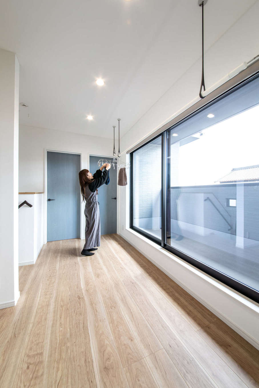 ナイスホーム【デザイン住宅、間取り、インテリア】2階のいちばん日当たりのいい場所を部屋干しスペースに。夜洗濯して干しても朝にはほとんど乾いているそう。もちろん、天気のいい日は、軒の深いバルコニーで外干しも行う
