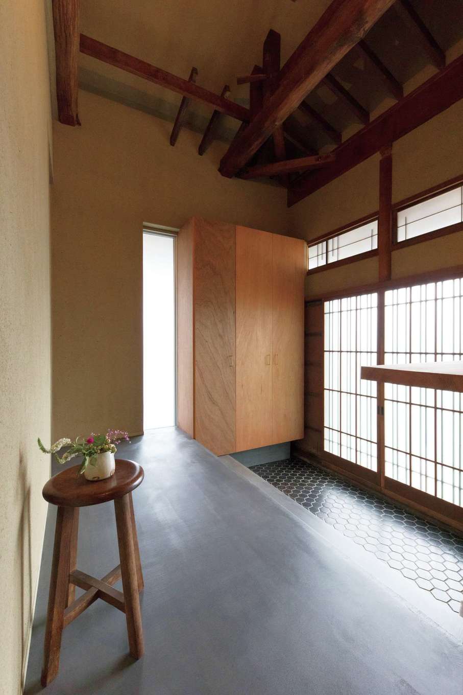 建杜 KENT（大栄工業）｜玄関ホールの床と式台もモルタルの床に。そのまま生かした三和土（たたき）のタイルがレトロモダンの空間づくりに一役買っている