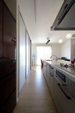 モデルハウスを見て採用した食器棚。半透明の引き戸で調理家電や食器を隠し、空間をすっきりと見せる。ダイニングテーブルをキッチンの横に配置したことで、配膳やお片づけの時間を短縮できる