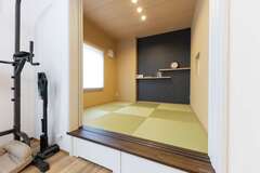 和室はLDKとの一体感を意識して、モダンな仕上がり。ネイビーのクロスをアクセントに用い、飾り棚を造作してもらった。小上がりの下部は収納になっている