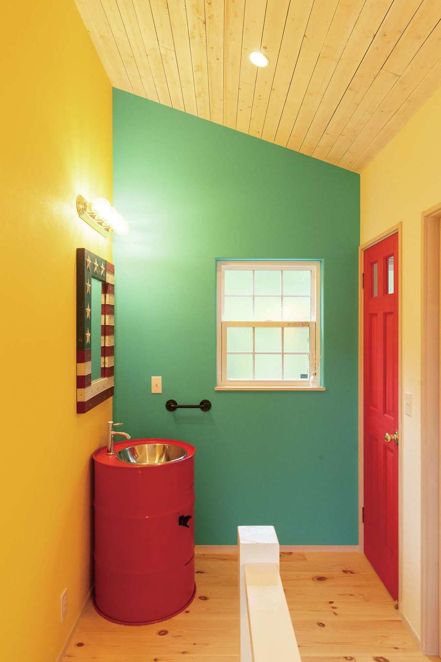 富士ホームズデザイン【輸入住宅、趣味、ガレージ】ポップな色使いの2階ホール。主張ある洗面台＆鏡もフィットする