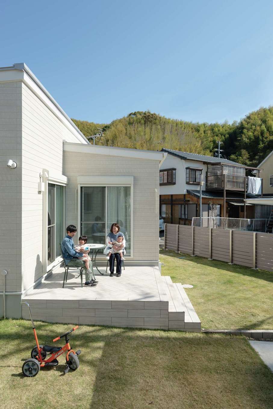 HAPPY HOUSE（山田工務店）【デザイン住宅、間取り、平屋】室内と庭をつなぐデッキはメンテナンス性を考慮してタイル張りに。バーベキューや芝生の庭で遊ぶお子さまたちの見守りに活躍