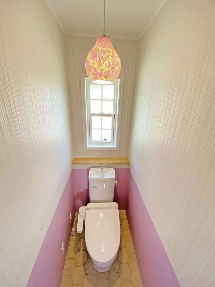 トイレは、トリム使いのクロスとペンダント照明をチョイスし、ピンク系でコーディネート