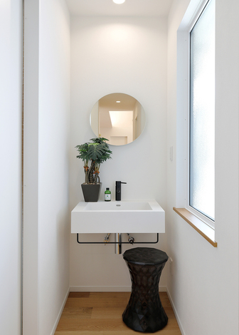 丸い鏡がかわいらしいセカンド洗面スペース。ちょっとした手洗いに便利。大きな窓から光が入って明るく清潔感がある