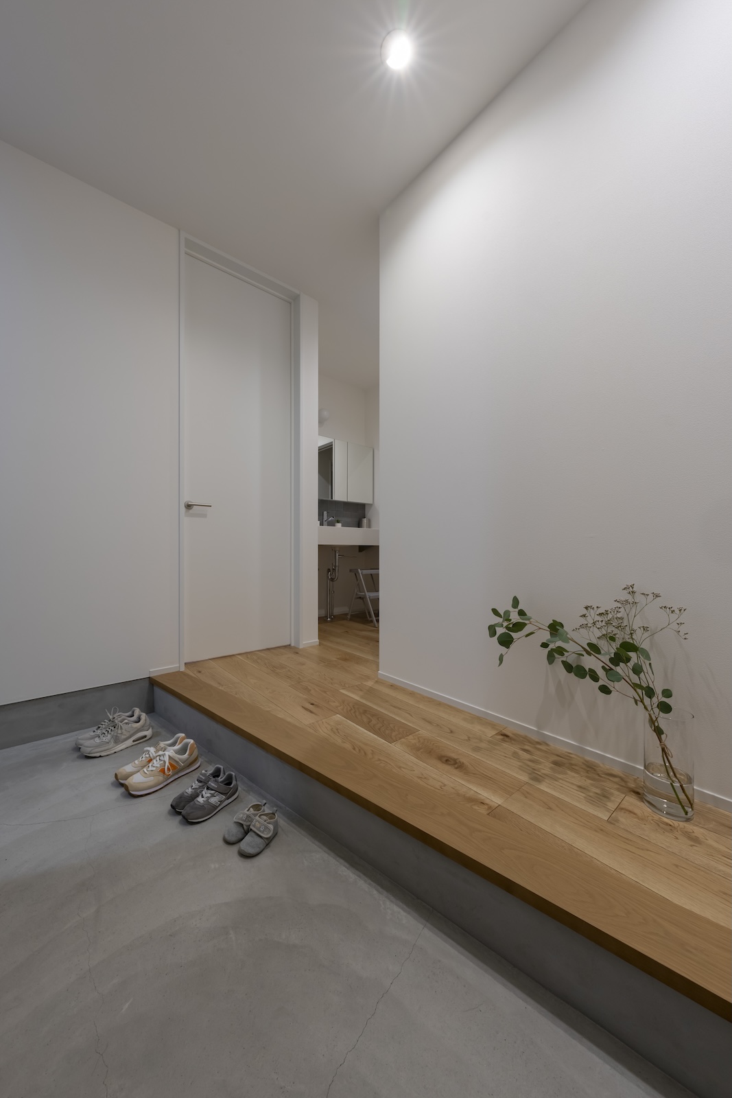 コラボハウス｜シンプルなデザインの土間。ナチュラルな木材とコンクリートの組み合わせが、モダンで落ち着いた印象を与えている。靴がすっきりと整頓された空間。
