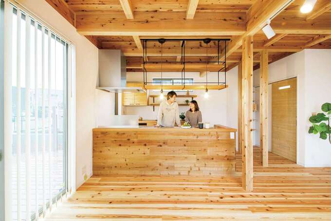 奥さまが最もこだわったキッチンは、あえて外で寝かせた粗木（構造材）で造作したオーダーメイド。天竜杉の床、天井ともしっくり馴染んでいる