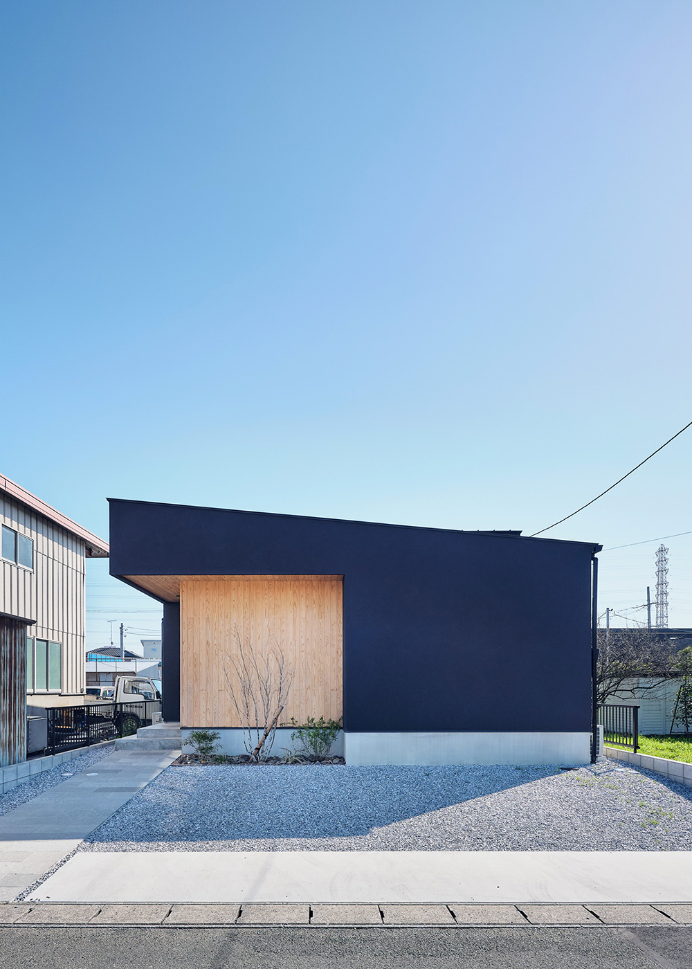 平屋建築ブルーハウス【デザイン住宅、間取り、平屋】高くせり出す片流れのフォルムと、塗り壁やスギの素材感が印象的な外観