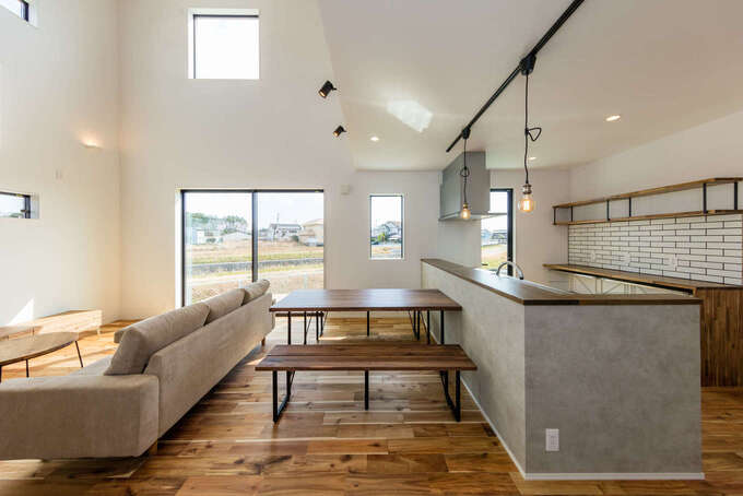 白・黒・グレーと木目でコーディネートされたLDK。照明や家具のセレクトにも施主さんのセンスが光る。光と風を効率よく取り込めるような窓の位置と大きさに建築家の経験値が息づいている