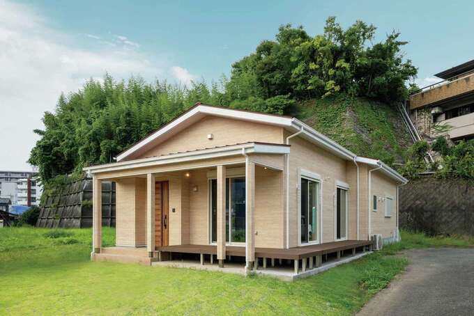 地中海のリゾート邸宅を思わせる外観。ベージュの外壁に赤い屋根、L字型のウッドデッキもこだわり