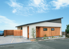 塗り壁とレッドシダー張りで仕上げた平屋の外観は、住宅街でもパッと目を引くデザイン。周囲の視線に配慮し、木製のフェンスでテラスを囲っている