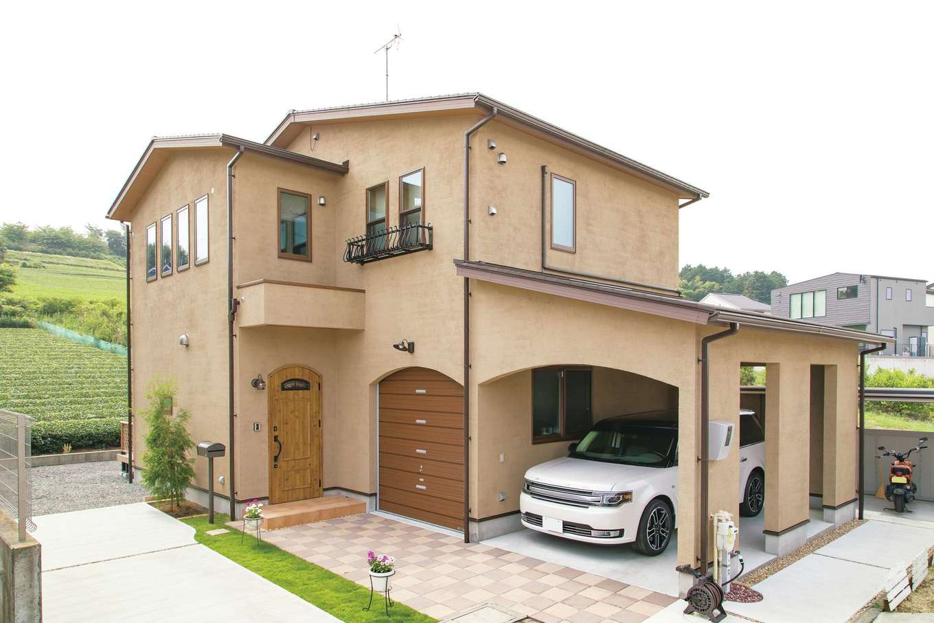 アキヤマ【自然素材、間取り、ガレージ】風合いのあるジョリパットくし引き仕上げの外壁とアールのラインが、やさしい印象を与える外観。窓の花台や照明など細部までデザイン性を重視