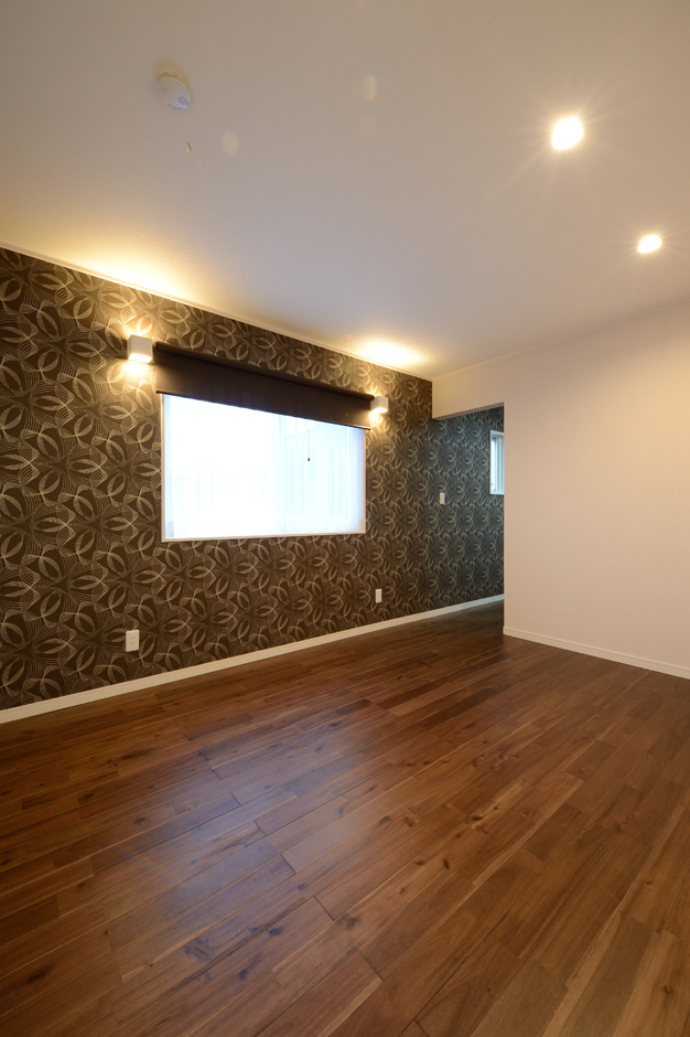 主寝室は一面だけクロスの柄を変えてムーディーに演出。間接照明の陰影美もコーディネーターによって計算し尽くされている。床は無垢のアカシア材を使うことで、重厚感を出した