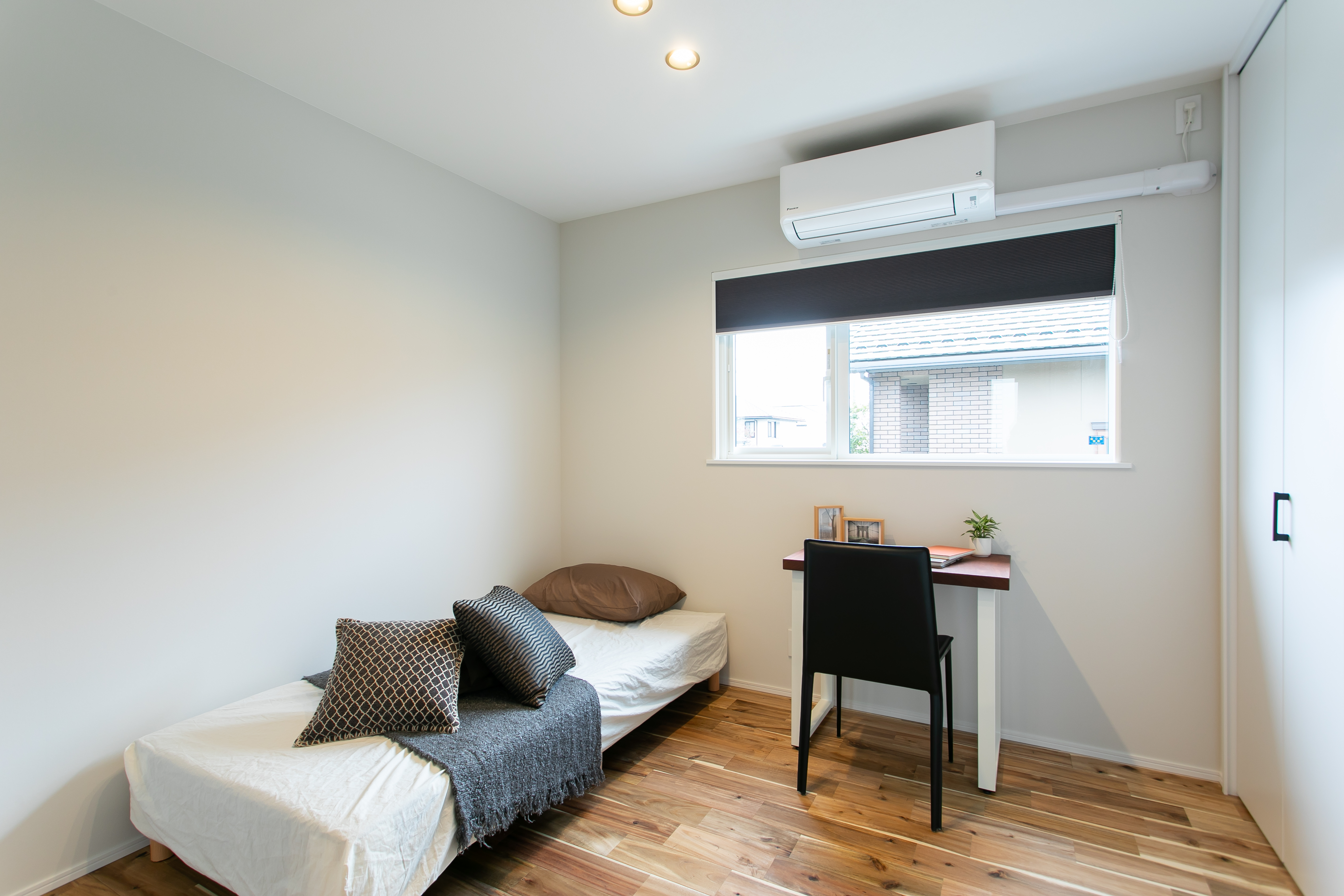 HOME CRAFT｜シンプルで機能的な子ども部屋。コンパクトなデスクスペースがあり、学習環境にも適している。ナチュラルな木目調の床が温かみを感じさせる。