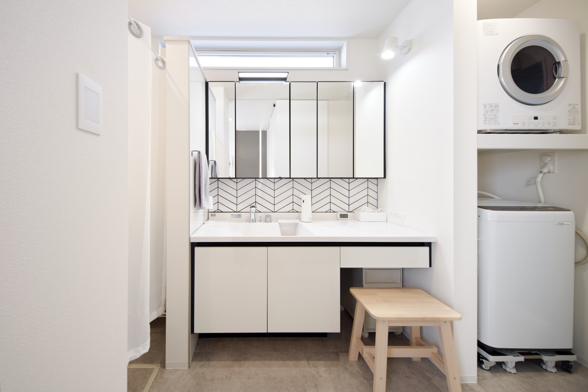 アサヒグローバルホーム｜ランドリールームと洗面室を兼ねた、広々とした機能的な家事空間。ガス衣類乾燥機にかけた洗濯物は洗面台横のカウンターで畳んで、下のBOXにそのままサッと収納できる