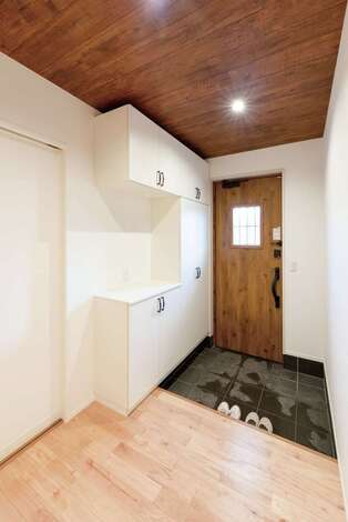 玄関は、必要最低限の収納でスペースを確保し、広々と開放的な空間に仕上げた