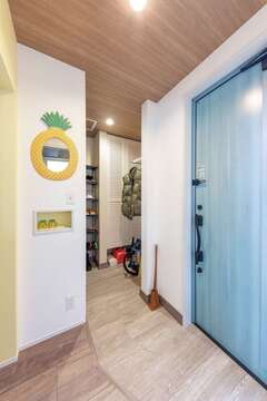 収納たっぷりの土間玄関。木目調のクロスがぬくもりを感じさせる。小物や雑貨にもとことんこだわった