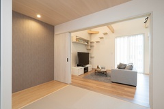 リビングに隣接した畳スペースが広がる。スライドドアを開放すれば一体的な空間が広がり、多目的に利用できる設計である。