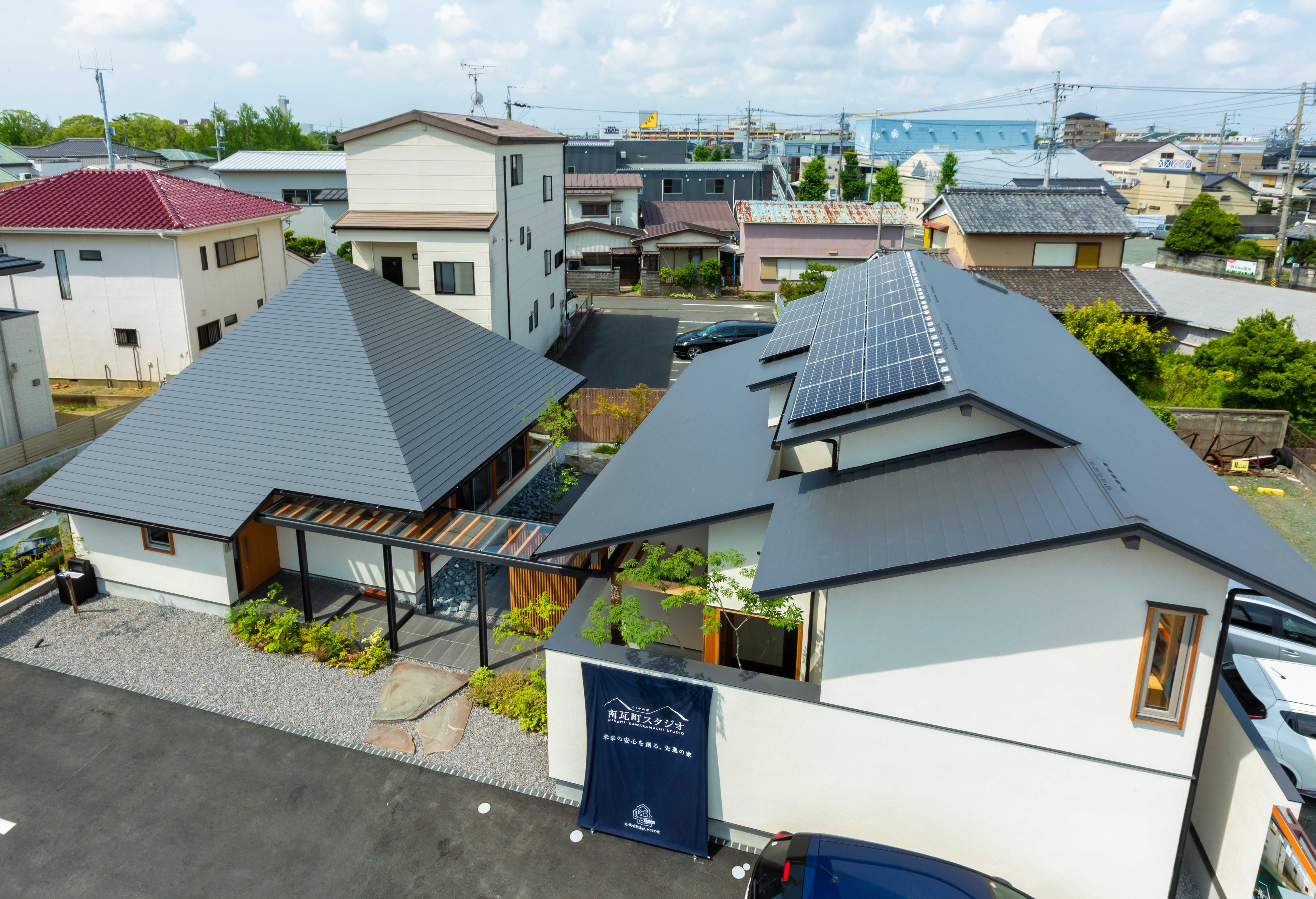 白と黒を基調にしたモダンな外観。左の建物がオフィス棟で、右は2階建ての展示棟。