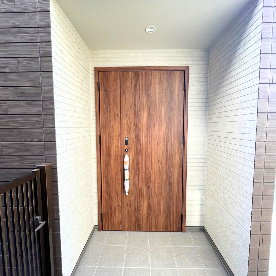 沢田建設｜木目調のドアが印象的な玄関。シンプルでありながらエレガントなデザインが魅力的で、訪れる人を温かく迎える。