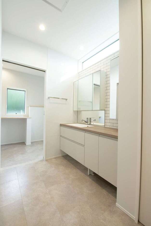 ホテルのパウダールームのような洗面所。奥には脱衣室があり、室内干し空間としても活用できる。来客があっても、脱衣所の扉を閉めるだけで洗濯物を隠せるから便利。洗面の向かいにはファミリークローゼットを用意