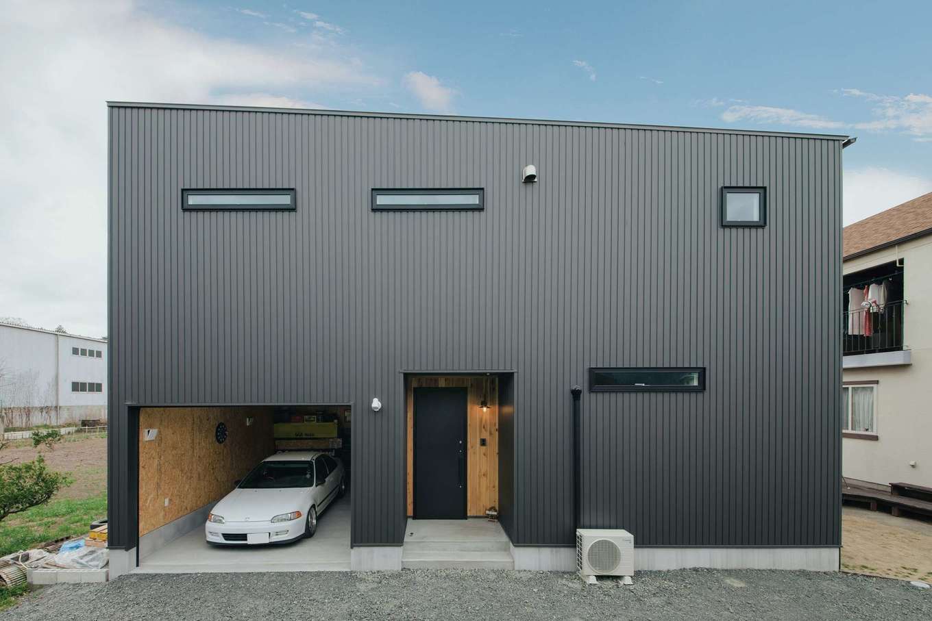 絆家（きずなや）【デザイン住宅、趣味、ガレージ】玄関の隣にガレージをビルトイン。シンプルな外観デザインに愛車が映える