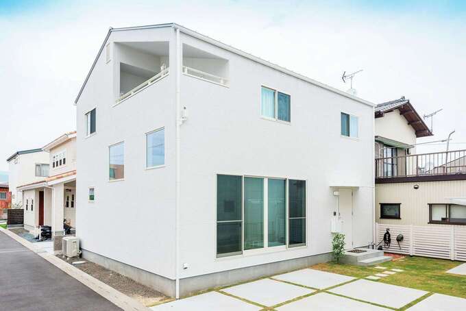 外観は真っ白な外壁と切妻屋根でスタイリッシュな印象。ゆとりのある駐車場はシンプルに