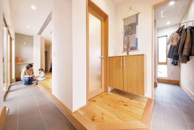 玄関を入ってすぐの室内の景色。右は収納、中央は玄関ホール、左はリビング。これらを土間がつなげている