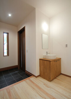 玄関には帰宅後すぐに手を洗えるよう手洗いを設置。来客には右側にあるトイレを使用してもらうことで、プライベート空間とのゾーニングを図っている