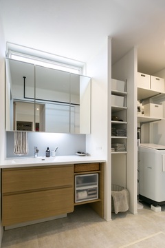 白と木を組み合わせた造作洗面台。
鏡上に配置した窓から柔らかい光が洗面スペースを照らしてくれる。