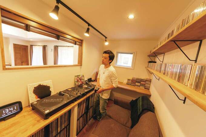 リビングの一角に設けたDJブース。青春時代の“遺産”として眠っていたレコード、CDも造作棚にディスプレイ。細長い窓を覗くとキッチンの奥様と目線が合う。