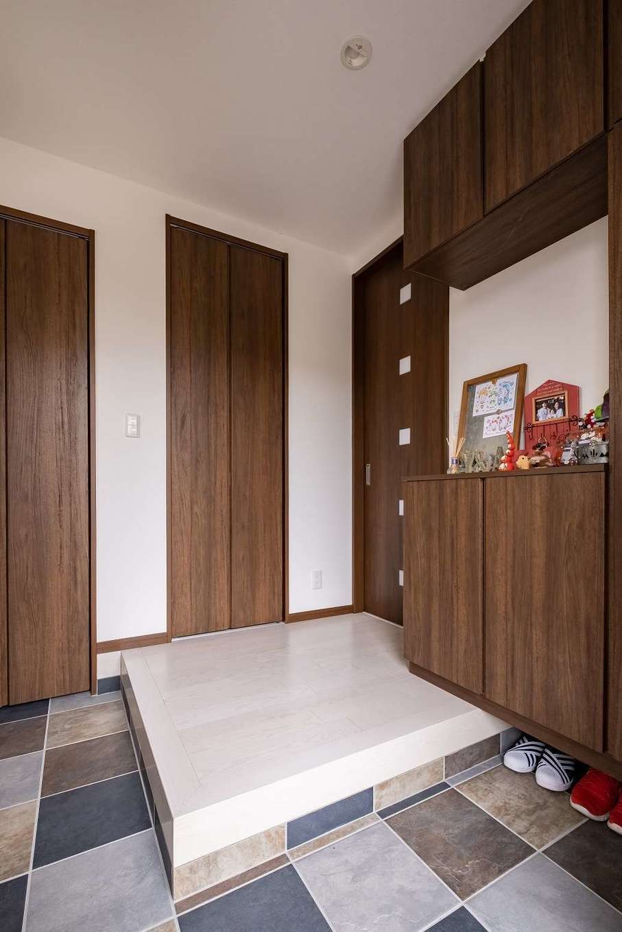 イデキョウホーム【デザイン住宅、省エネ、間取り】明るく落ち着いた玄関は収納も十分。床のタイルがアクセントに