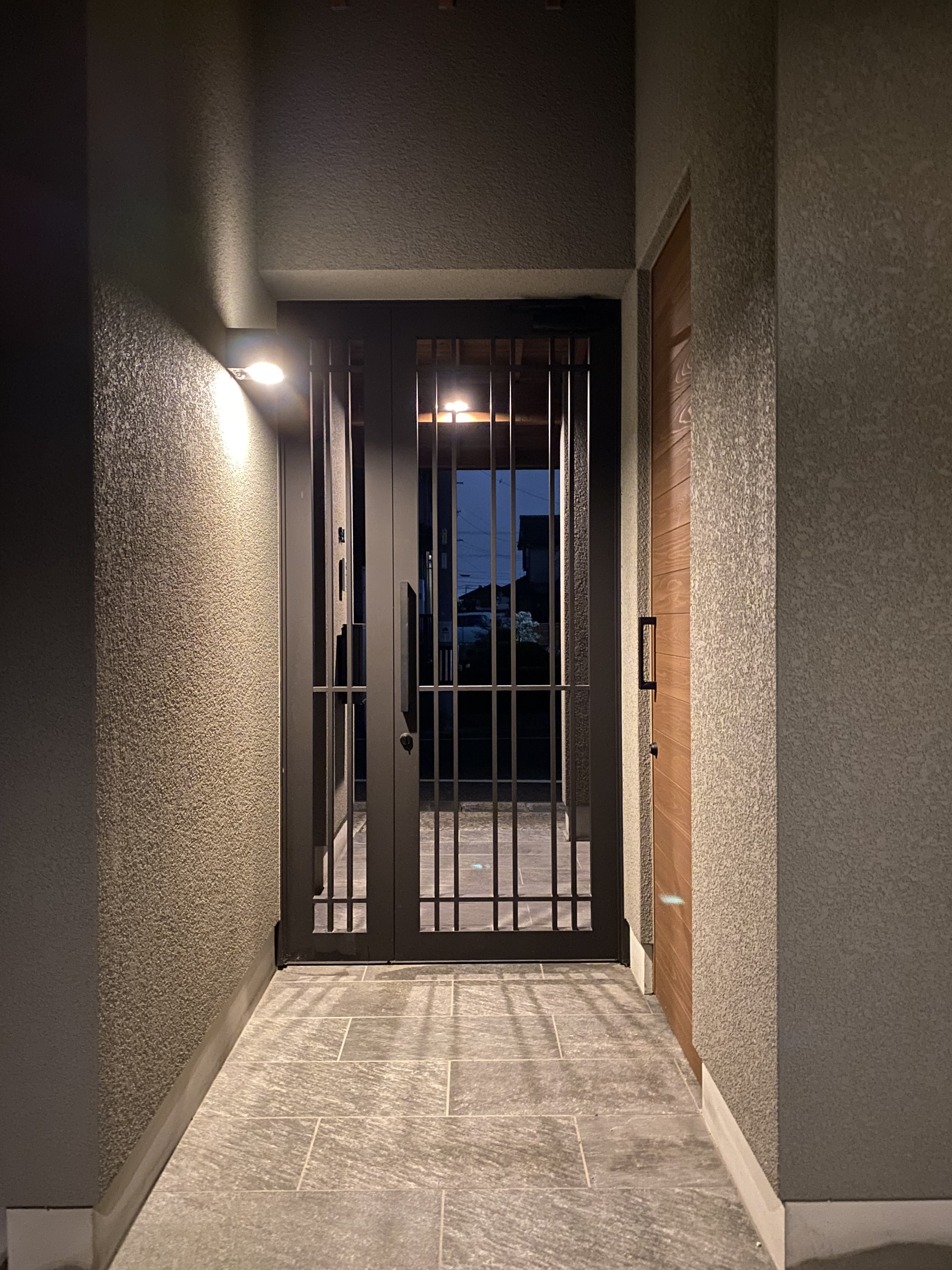 安田住宅｜安田建築設計室｜モダンで洗練されたデザインの玄関。間接照明が壁に控え目に映え、落ち着いた雰囲気を演出している。