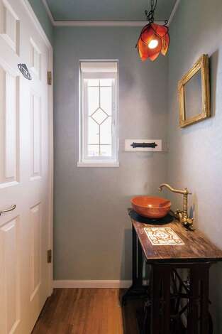 リッカーの古いミシン台をカスタマイズして作った洗面台。窓ガラスの格子もオーナーＴさんの手づくり