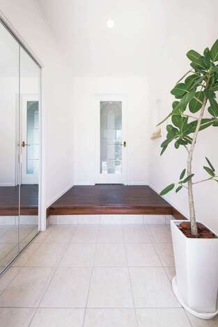 白を基調とした玄関。サイドのミラー扉の奥はシューズクロークになっている