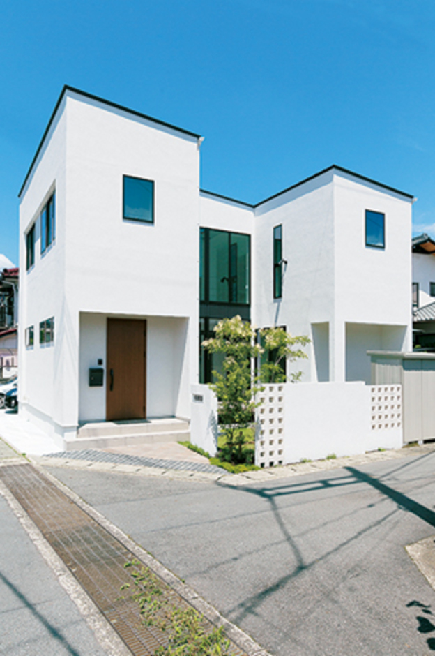 ジョリパッドの真っ白な外壁に、黒のサッシがひときわ目立つコの字型の外観