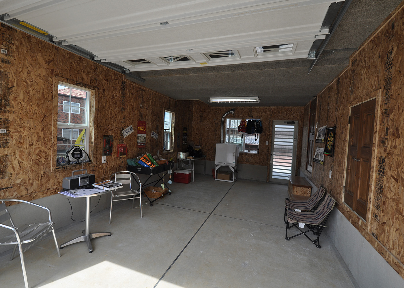 リンゾー【輸入住宅、ガレージ、デザイン住宅】ゆったりサイズのビルトインガレージ。奥は吹抜け。シャッターはオーバースライダーで楽々開閉。玄関のシューズクローゼットと脱衣室の2か所に室内との出入口がある