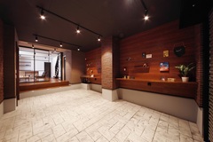 木目調の壁とタイル張りの床が調和した土間。壁のディスプレイスペースがアートギャラリーのようであり、趣味の品を楽しむ空間としても最適
