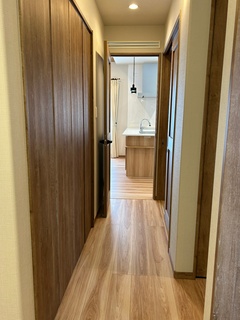 シンプルで落ち着いた木目調の廊下が、リビングへとつながっている。適度な照明が心地よい雰囲気を作り出している。