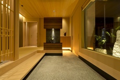 玄関は旅館のような迫力のある風情。贅沢な広さを確保し、窓の外には庭が眺められるようにした