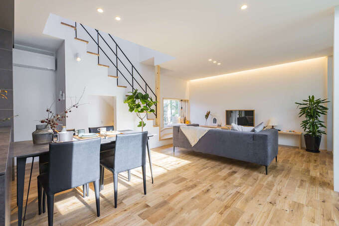 南北の開口部や吹き抜けから十分な採光を確保した開放的なLDK。無垢の床や造作の木のT Vボードが温かみを感じさせる。道路との間に中庭テラスを挟んだことで、騒音やホコリが気にならず、静かで快適な環境が実現