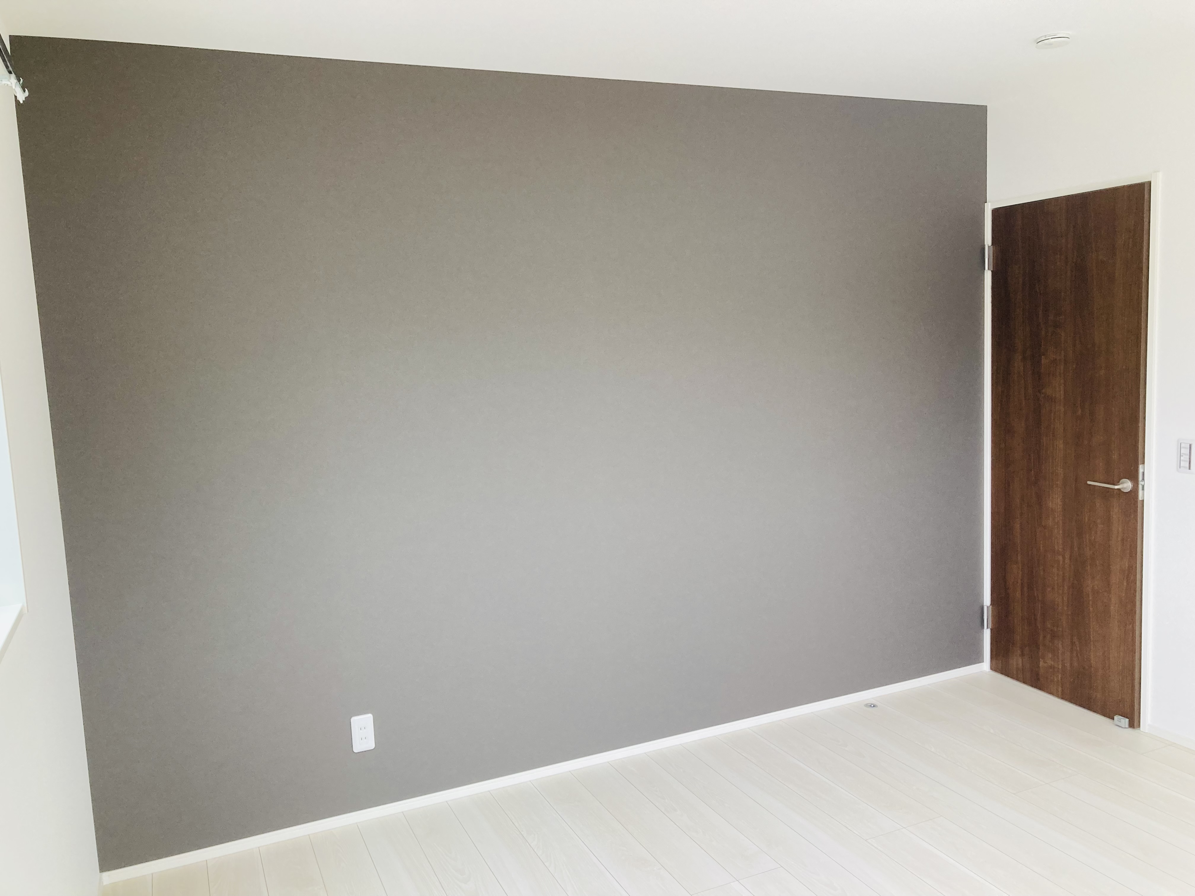 沢田建設｜シンプルで落ち着いた雰囲気の居室スペース。アクセントウォールが印象的で、家具の配置により多様なスタイルを楽しめる。