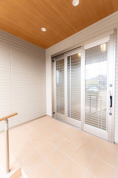 広々とした玄関スペースで、ナチュラルなタイルと木目調の天井が調和している。ゆるやかなスロープと手すりを設置しバリアフリーに配慮した。