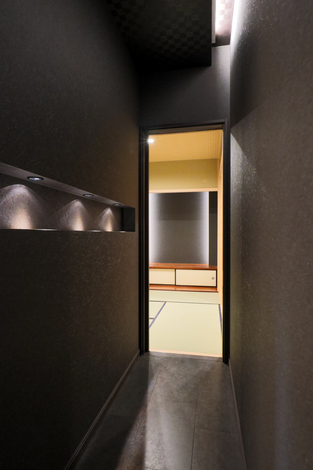 落ち着いた雰囲気の和室へと続く、シックな廊下。照明が和室のエントランスを優雅に演出している。