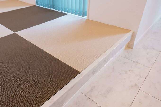 畳コーナーの立ち上がりにまで真っ白な大理石調のパネルを敷き詰めたLDK。木材とはまた違った、個性的な空間を演出できる。