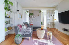 リビングの棚やオーディオラックなどの収納部には壁厚を利用。玄関ホールとの間に配した壁は黒板塗料で仕上げ、お気に入りの絵葉書や写真、イラストなどで楽しく演出