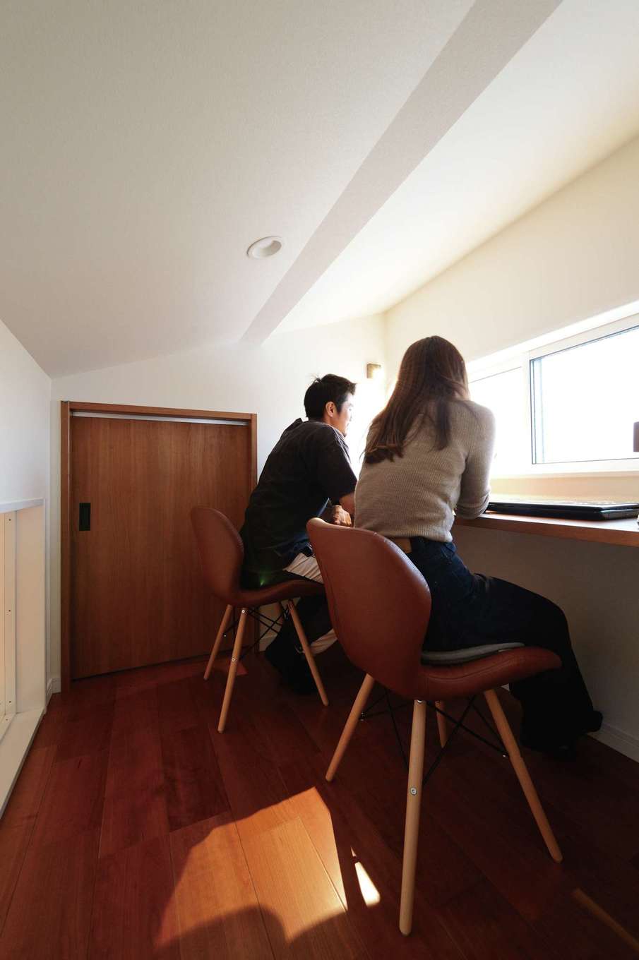 Yamaguchi Design 【デザイン住宅、省エネ、インテリア】2階のスタディコーナー。カウンターの背面の壁にはLDKの吹き抜けに面したフィックス窓を設けてある。フリースペースの奥には5畳もの広さの小屋裏収納がある