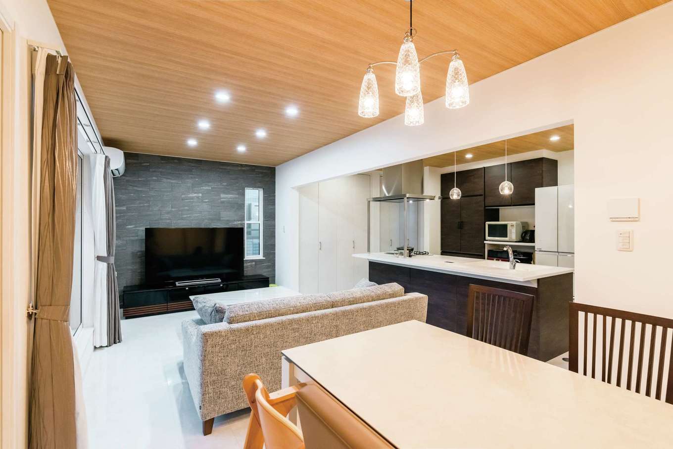 アイワホームサービス【デザイン住宅、屋上バルコニー、ガレージ】テレビボードの壁面は石材パネルでシックな仕上がりに。家の雰囲気に合わせて家具もコーディネート