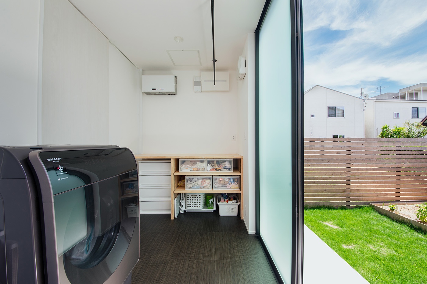 ハウスコネクト【デザイン住宅、趣味、建築家】部屋干しできるランドリールームからテラスデッキ、庭へと直結する動線。広いランドリールーム兼脱衣室は、子育て夫婦の気持ちにゆとりをもたらす
